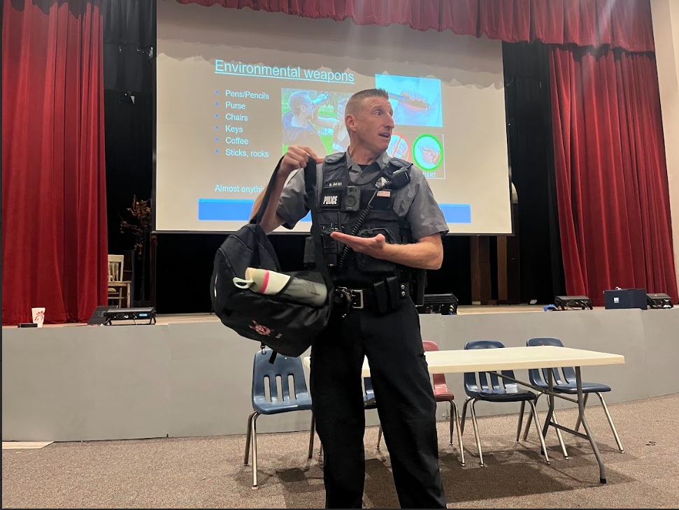 Officer Davis explains how everyday items can be used as weapons for defense in dire situations, presenting a heavy backpack as an example. The seminar educated students on when and how to define self-defense. 