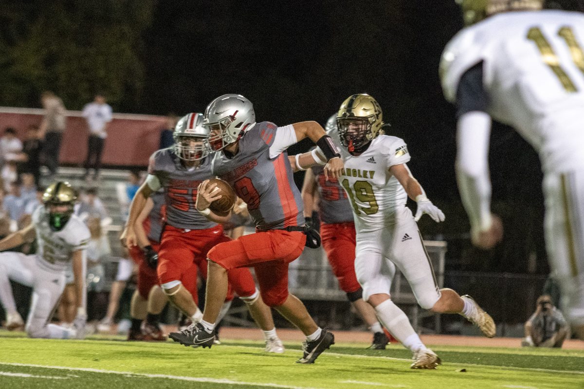 Junior Quarterback Christian McNeil scrambles for the first down. The Langley defense was stingy throughout the game, resulting in a need to improvise for the McLean quarterback.