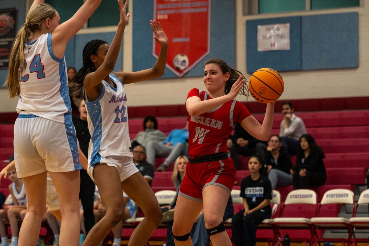 Senior wing Macy Crawford passes the ball as Marshall defenders close in on her.