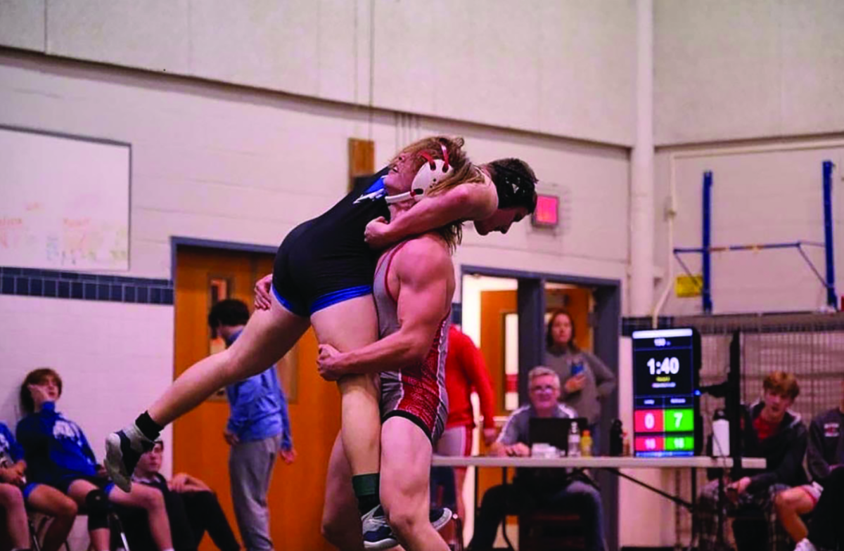 Senior Will Lewey overpowers his opponent during a wrestling match. Lewey's wrestling career has helped shape both his future and his aspirations. 