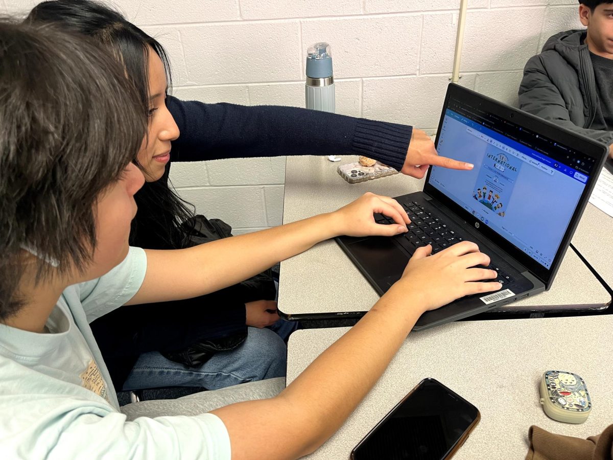 Students designing posters for the upcoming International Night this February. Icons that represent multicultural values are incorporated in the designs.