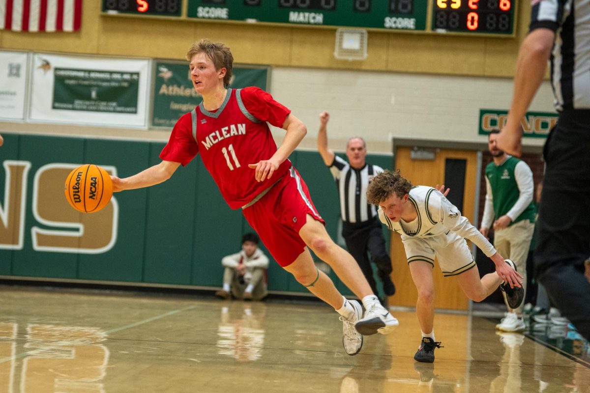 Senior Max Mullen swerves past a Saxon defender before sinking a three-pointer during the first half.