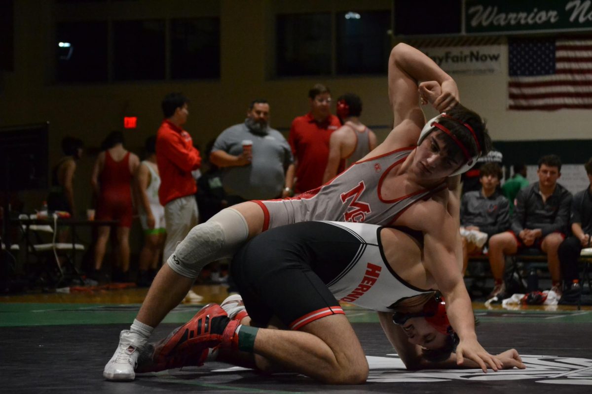 Sophomore Evan Herlands swiftly forces his opponent onto the ground. During the District Duels, McLean's wrestlers showed both skill and strength.