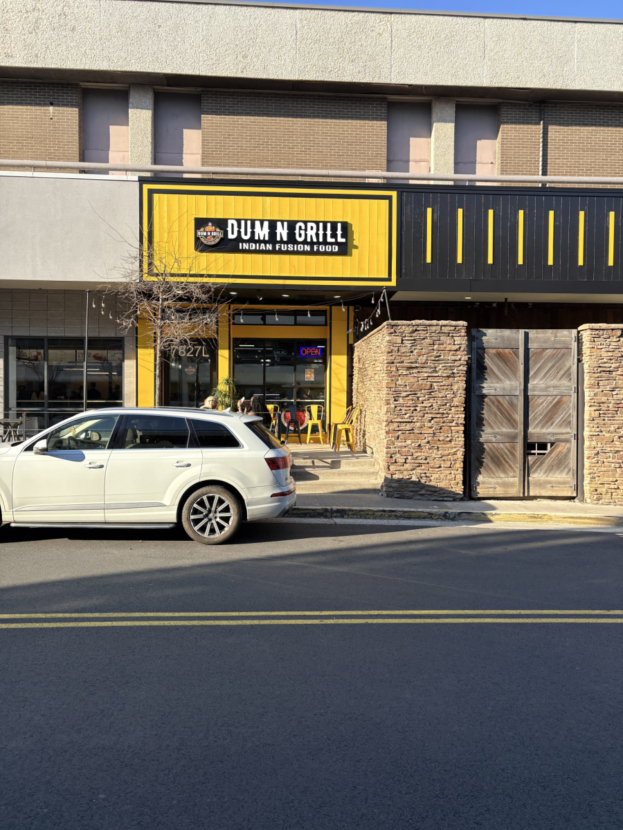The front of Dum N Grill, located on the exterior of Tyson's Corner Mall. The store front features bold contrasting colors- indicative of its bright interior. 