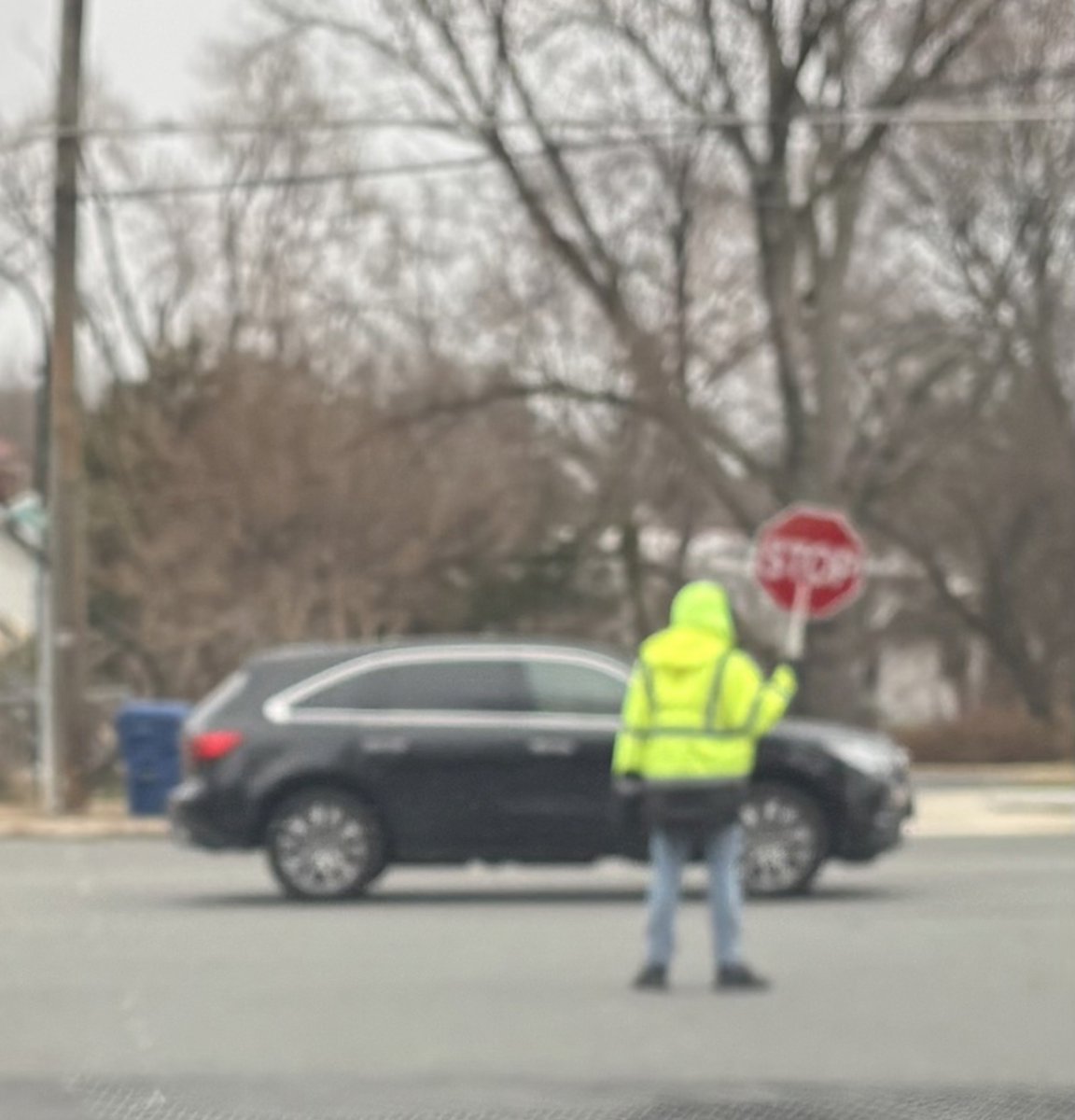 Crossing guard walks in front of Westmoreland exit to allow pedestrians to cross. 