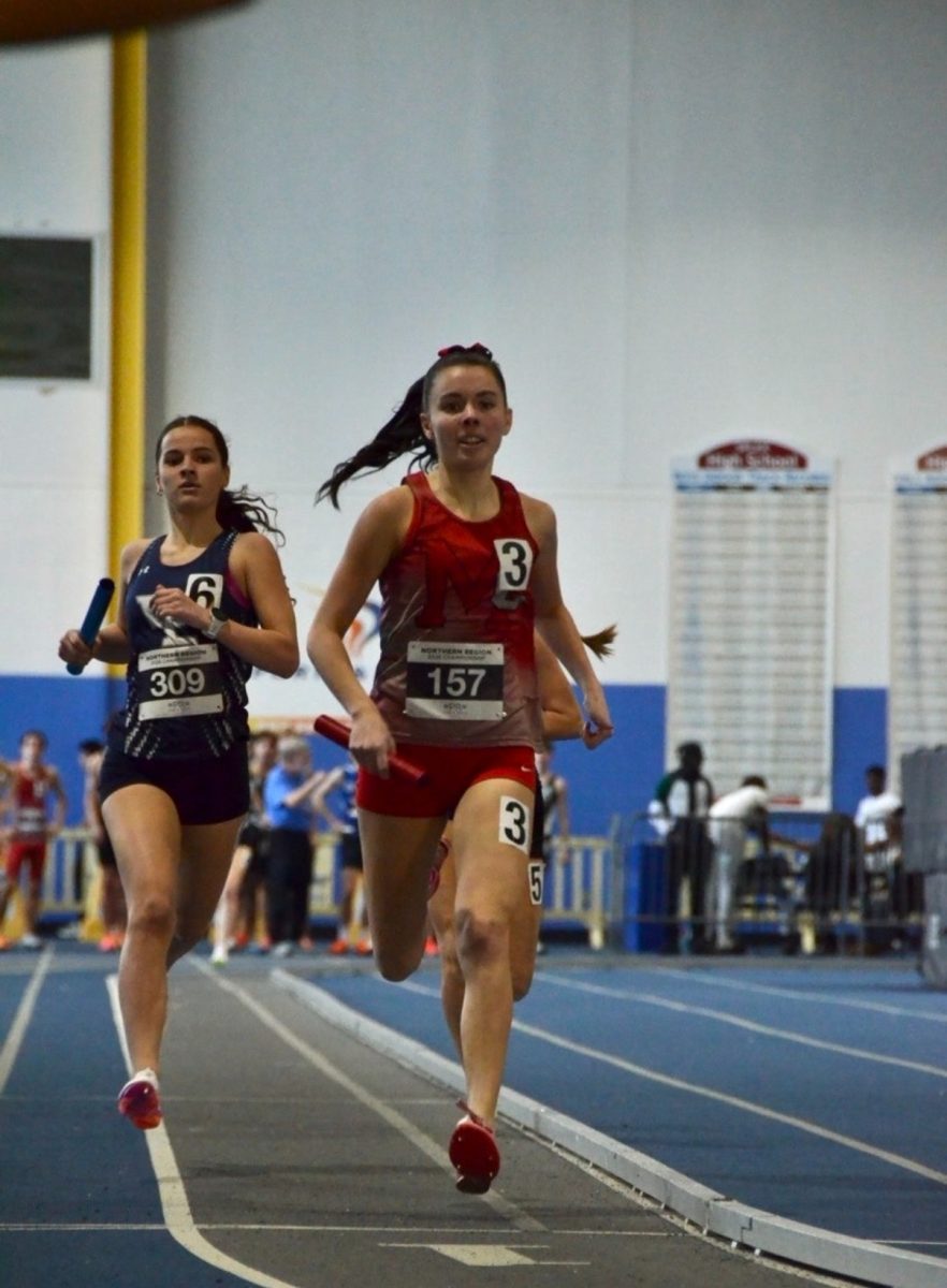 Jaidyn Buday races the 4x800 meter race in the Liberty District Indoor track district meet on Jan. 29. Buday brings her relay team to success, showcasing her raw talent for the sport.