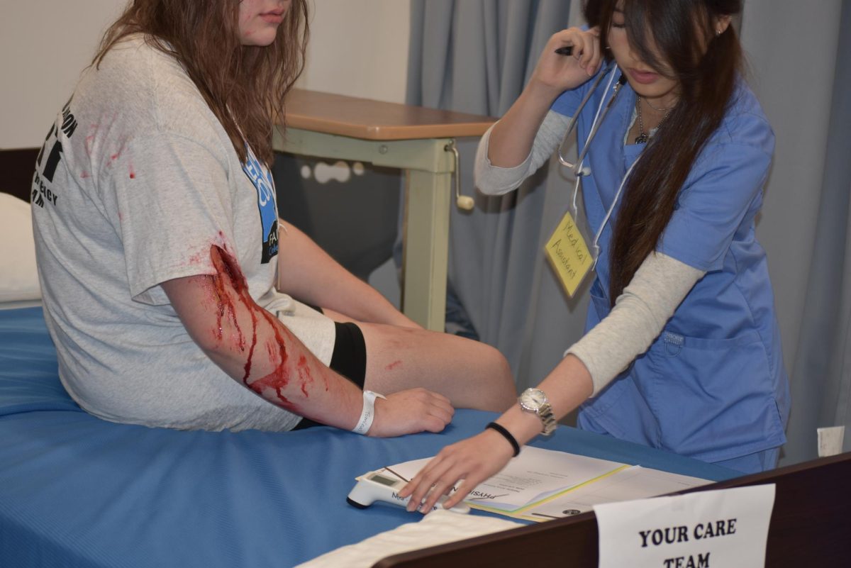 Medical assistant noting patient information in patient records.