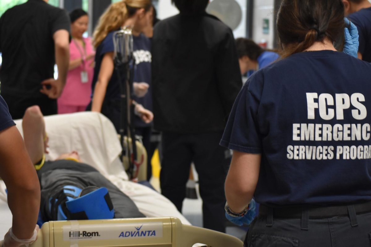 Falls Church Academy EMT students transporting patient on medical bed to simulated emergency room.